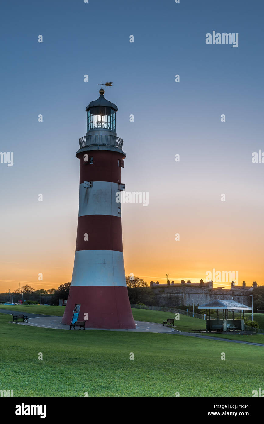 The sun rises behind the iconic Smeatons Tower on Plymouth Hoe in south Devon. Stock Photo