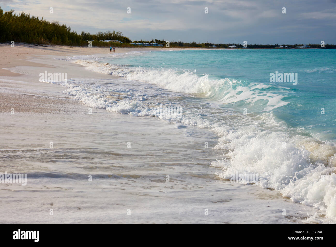 Couple walking along the beach Stock Photo - Alamy