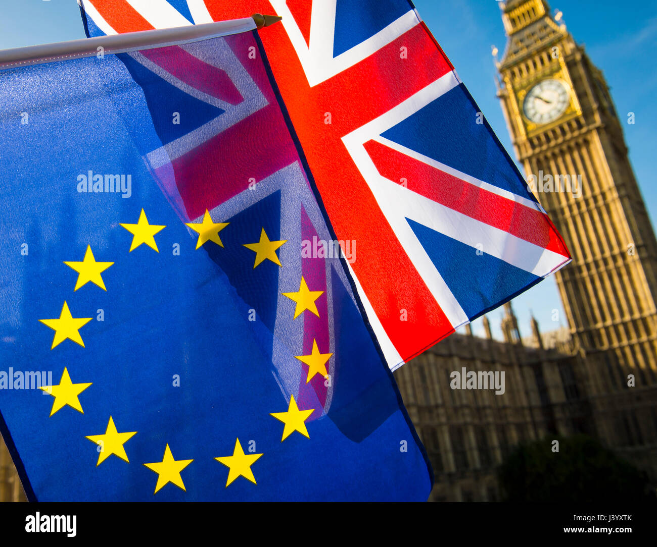 EU European Union and United Kingdom flags flying in solidarity in front of a bright morning view of Big Ben and the British Houses of Parliament Stock Photo