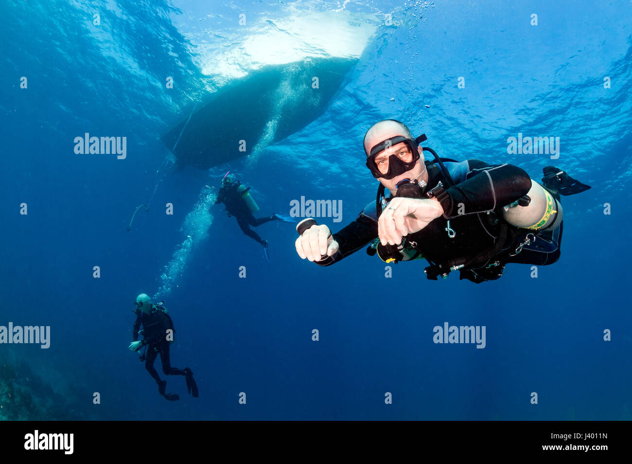 SCUBA diver in a technical sidemount cofiguration underneath a dive boat Stock Photo