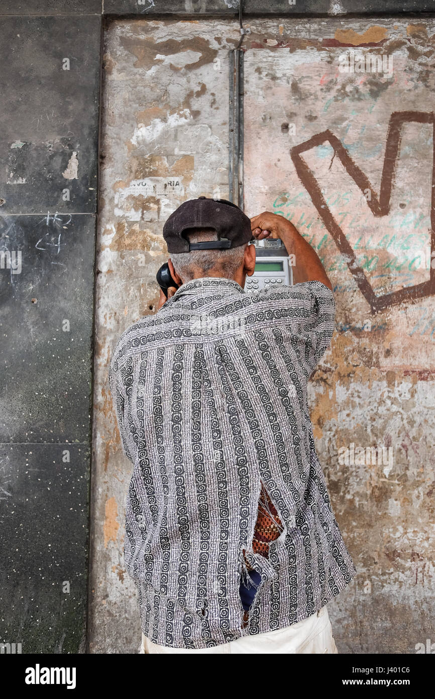 Elderly cuban man using a pay phone on the streets of Havana, Cuba Stock Photo
