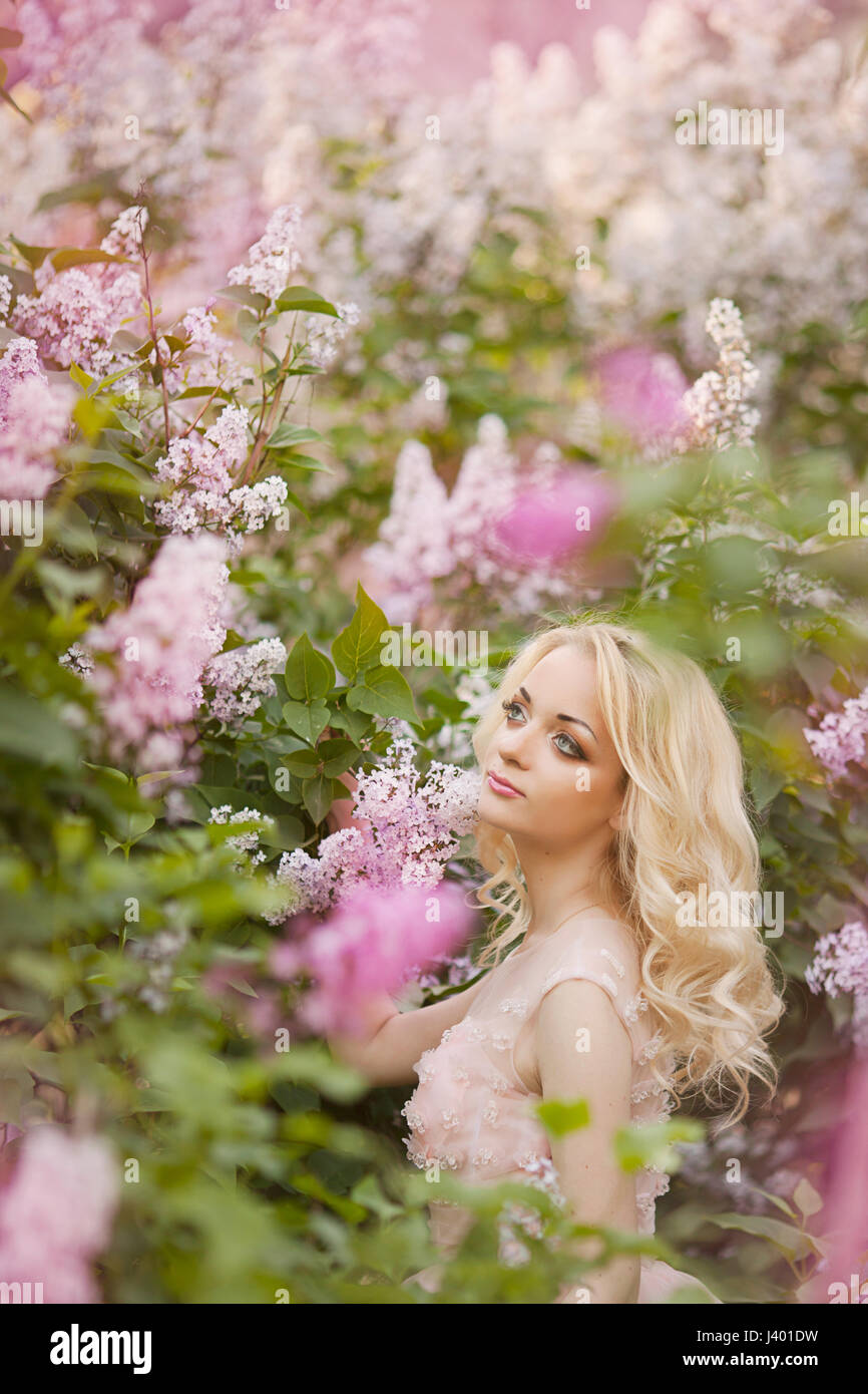 Beautiful woman enjoying lilac garden, young woman with flowers in ...