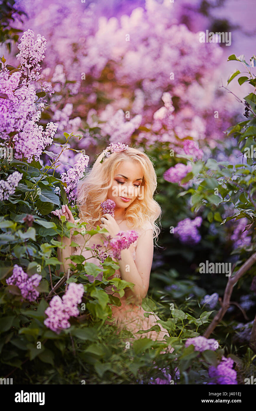 Beautiful woman enjoying lilac garden, young woman with flowers in ...