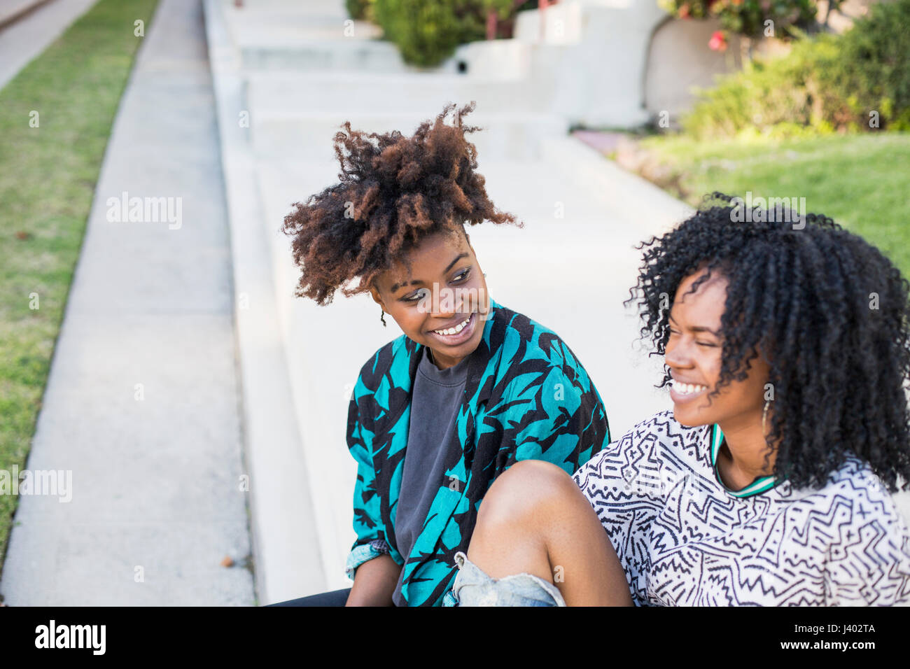 Young women sitting on pavement hi-res stock photography and images - Alamy