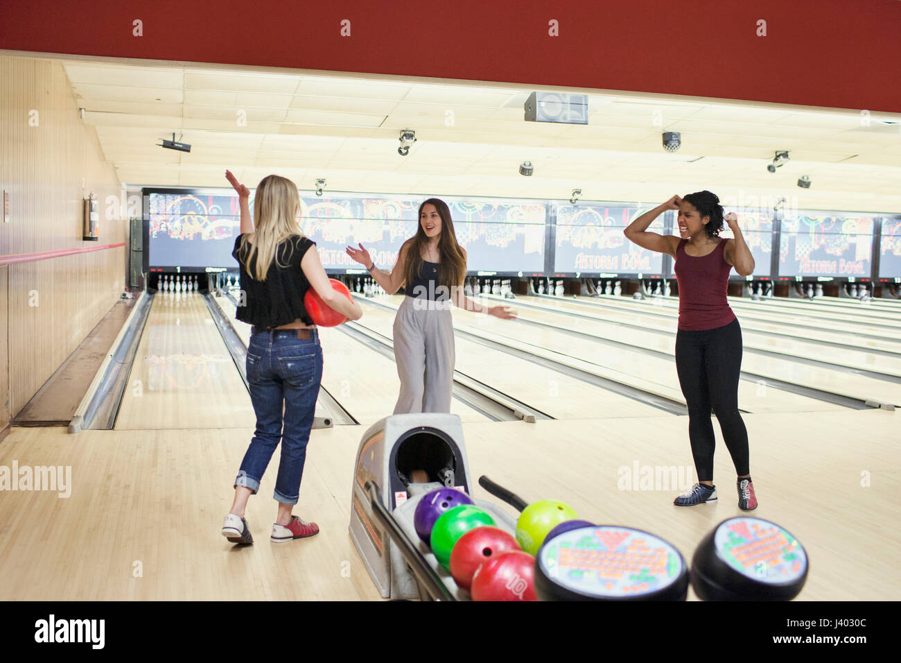 Three young women bowling Stock Photo Alamy