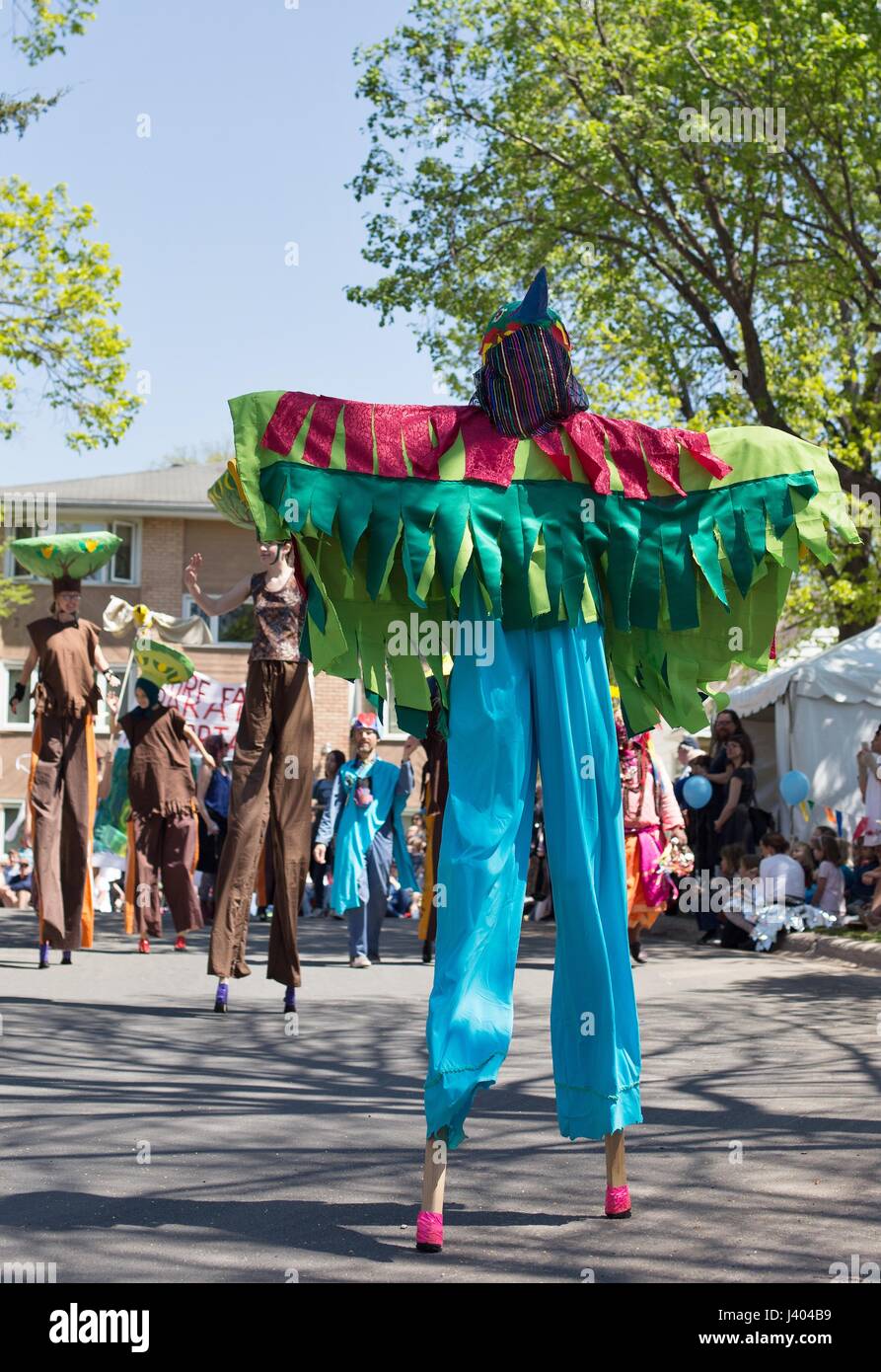 A person dressed as a bird, walking on stilts at the Mayday parade in