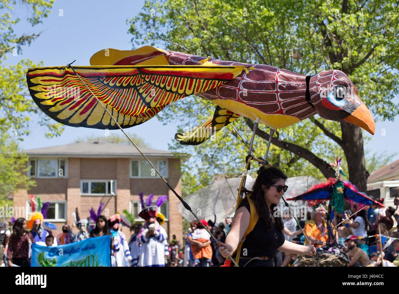 A woman carrying a giant bird puppet at the Mayday parade in