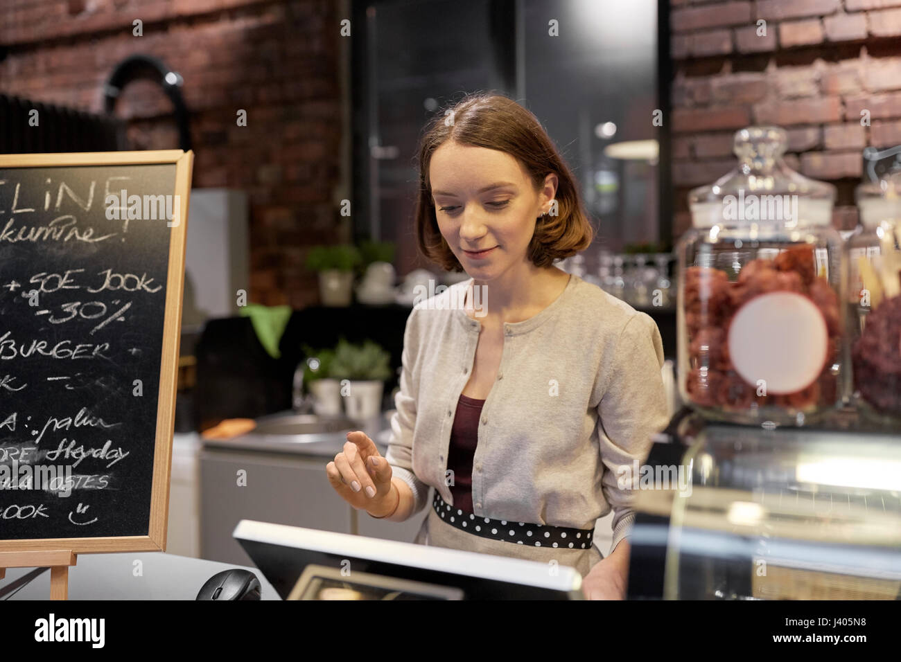 happy woman or barmaid with cashbox at cafe Stock Photo
