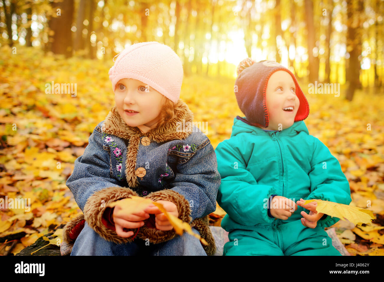 Brothers and sister playing outside in Autumn leaves Stock Photo - Alamy