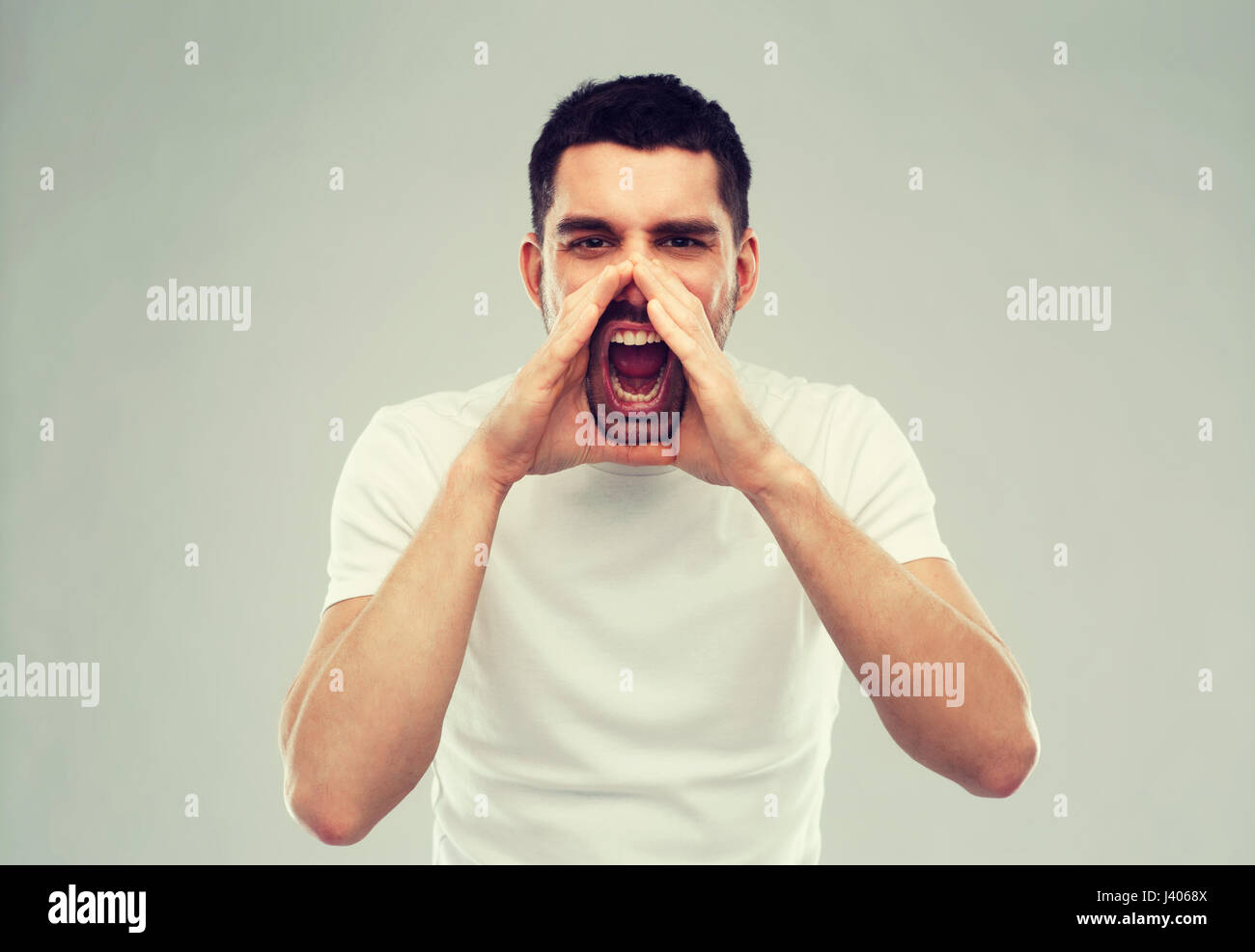 angry shouting man in t-shirt over gray background Stock Photo