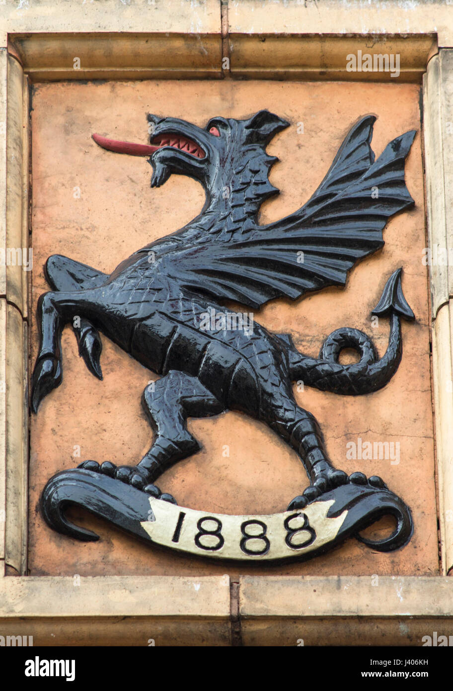 Black Griffin with red tongue and red eyes mounted on a stone plaque Stock Photo