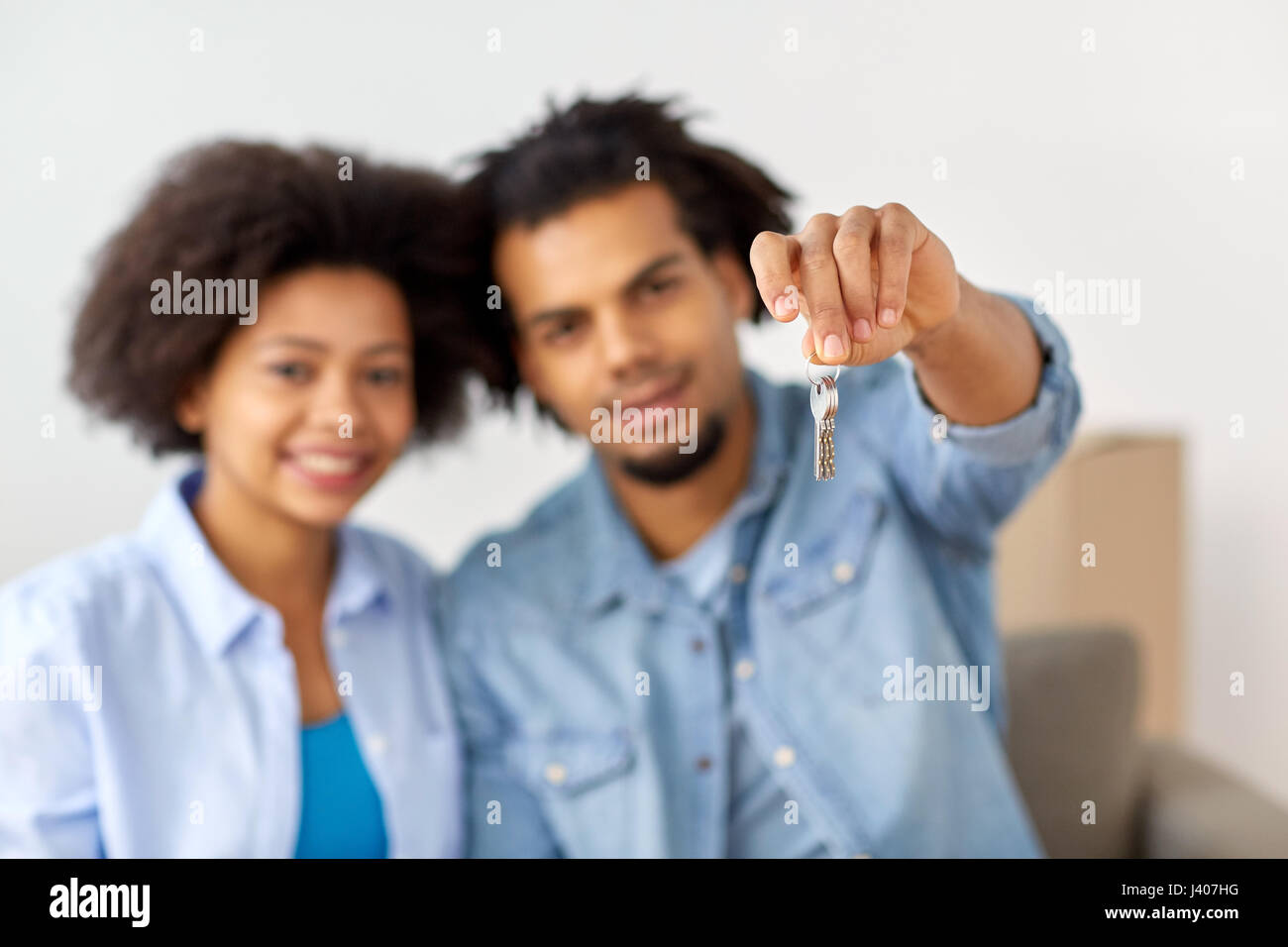 happy couple with key and boxes moving to new home Stock Photo - Alamy