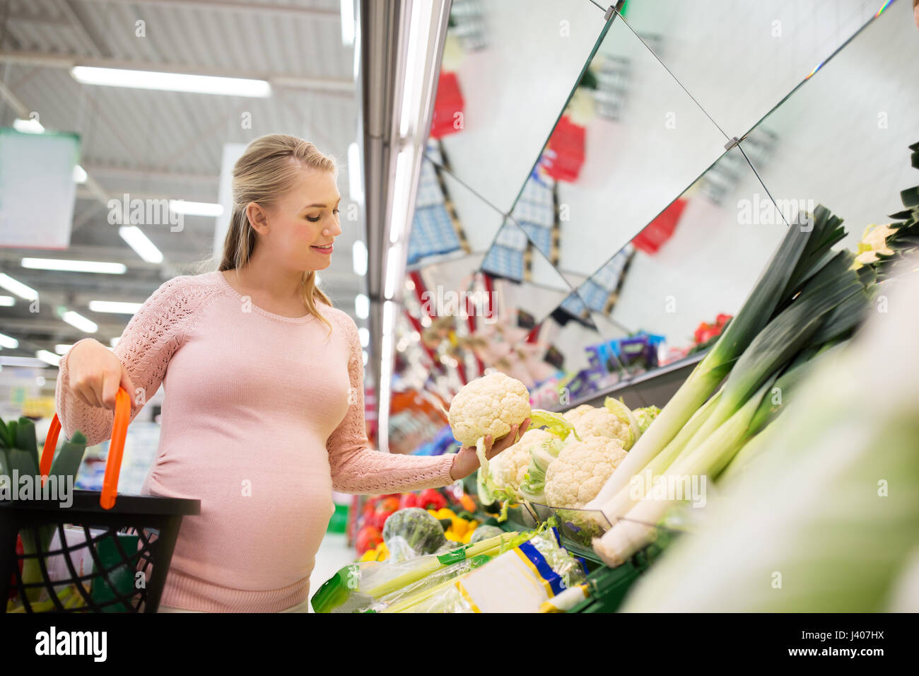 happy pregnant woman buying cauliflower at grocery Stock Photo Alamy
