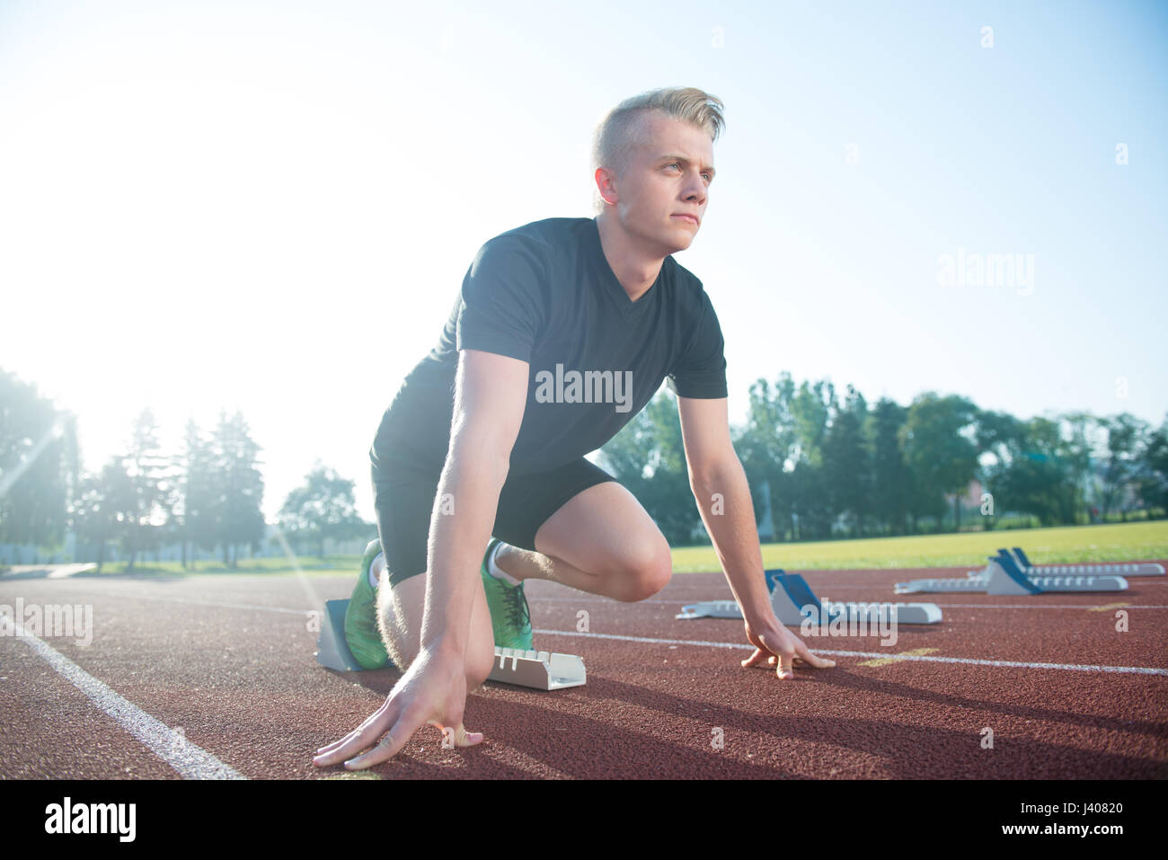 Runners preparing for race at starting blocks Stock Photo Alamy
