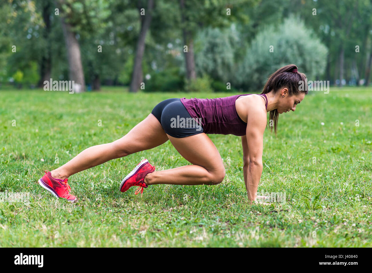 Young woman taking exercises in a park Stock Photo - Alamy