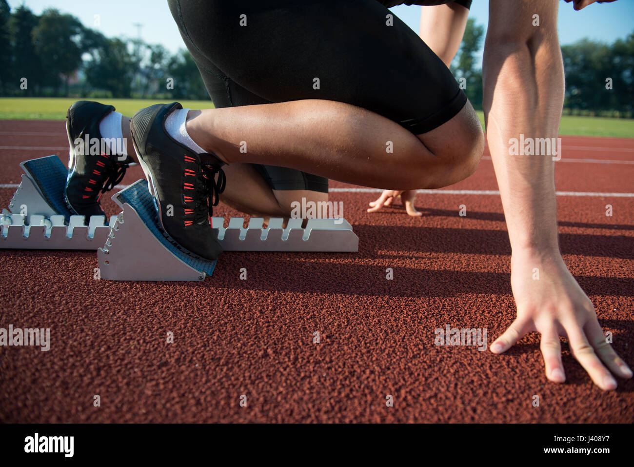 Runners preparing for race at starting blocks Stock Photo Alamy