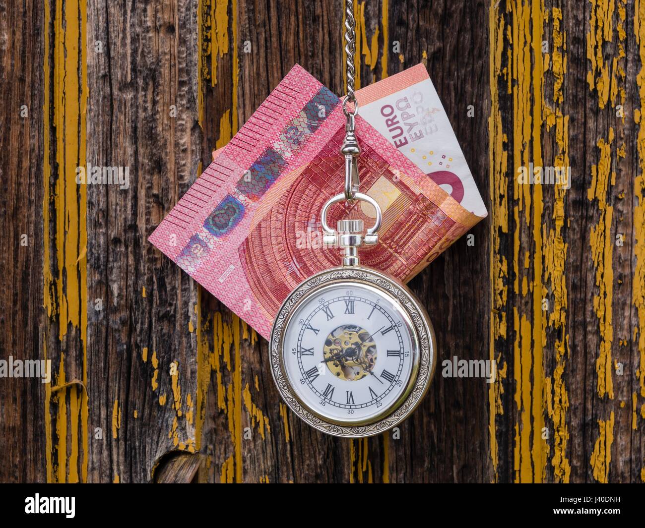Time is money euro and vintage pocket watch clock before derelict