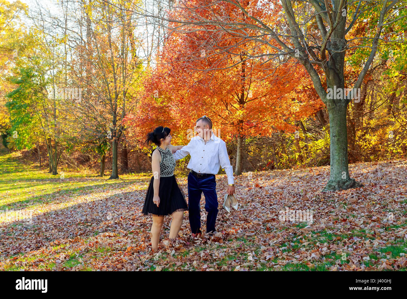 Young couple in love holding hands and walking through a park on a ...
