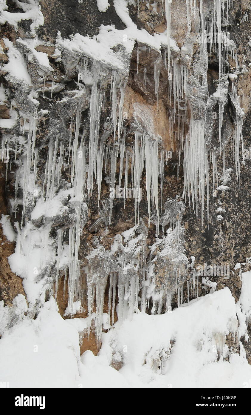 May icicles on an alpine rock wall. Stock Photo
