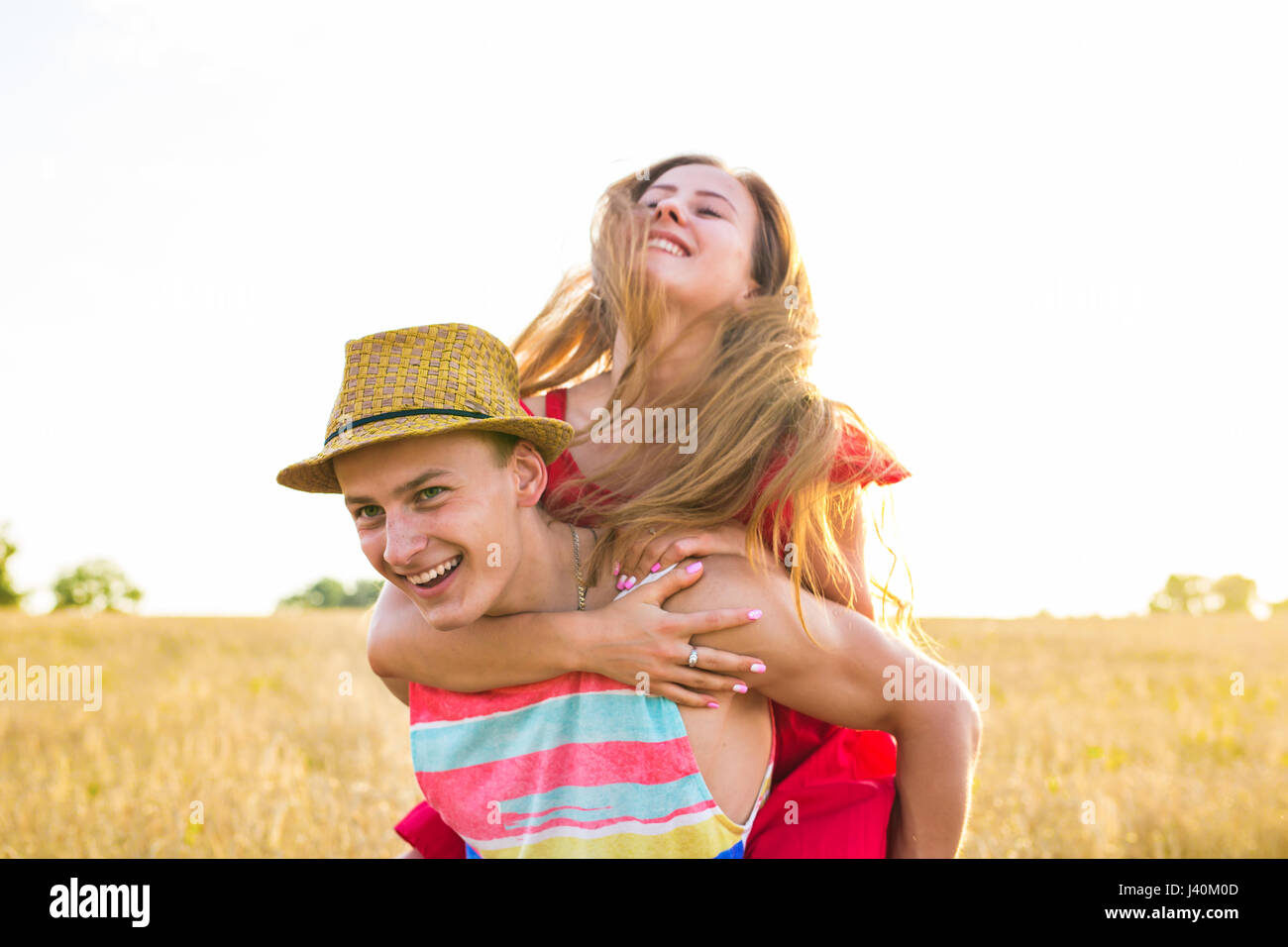 Happy Couple Having Fun Outdoors on field. Freedom Concept. Piggyback ...