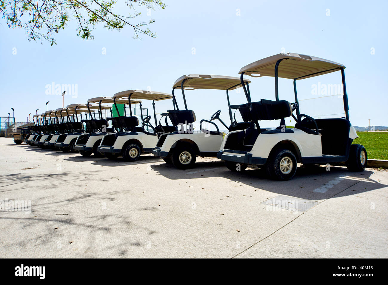 Golf cars or golf carts in a row outdoors on a sunny spring day Stock Photo