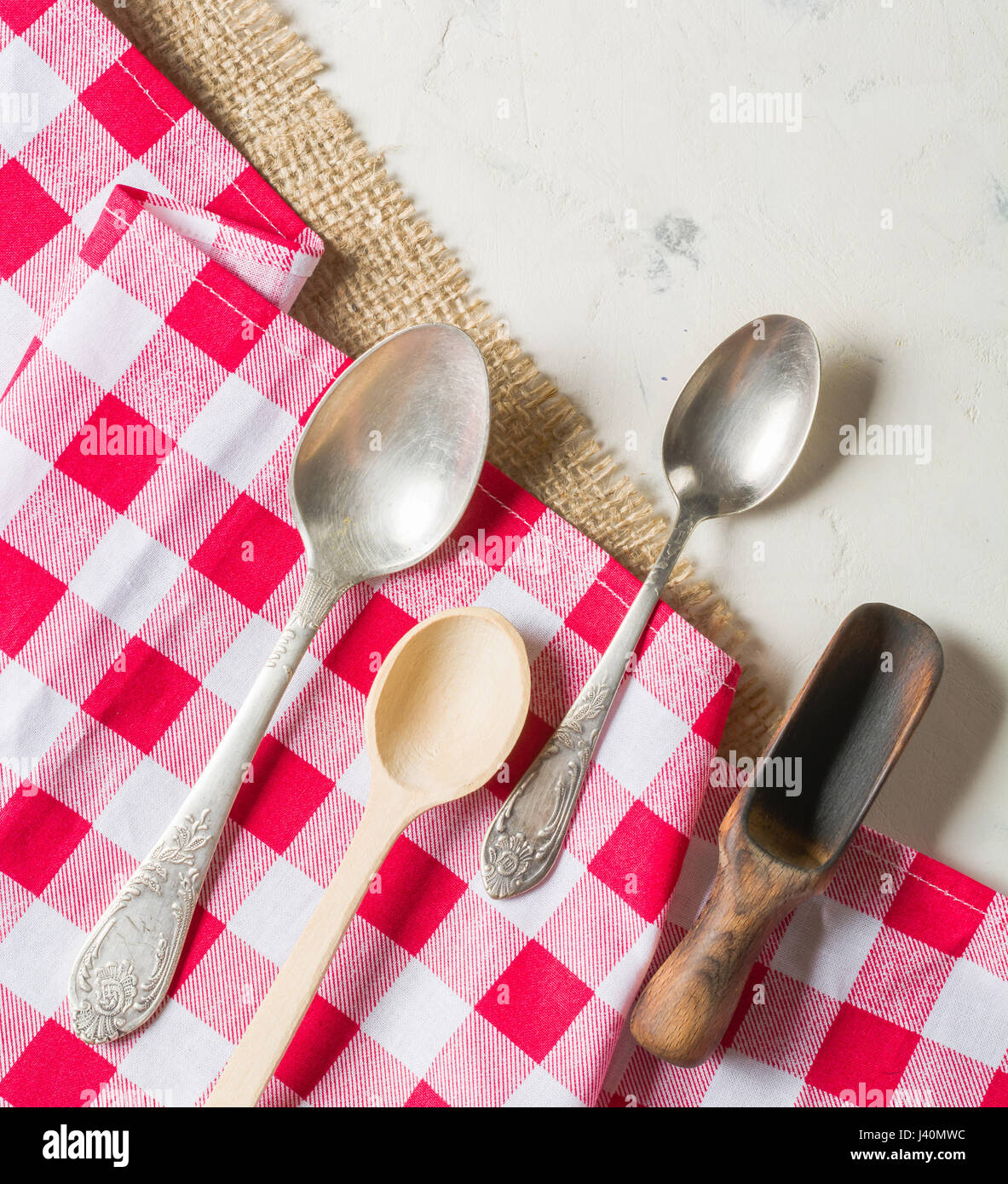 Different spoons made of wood and metal on a light background Stock