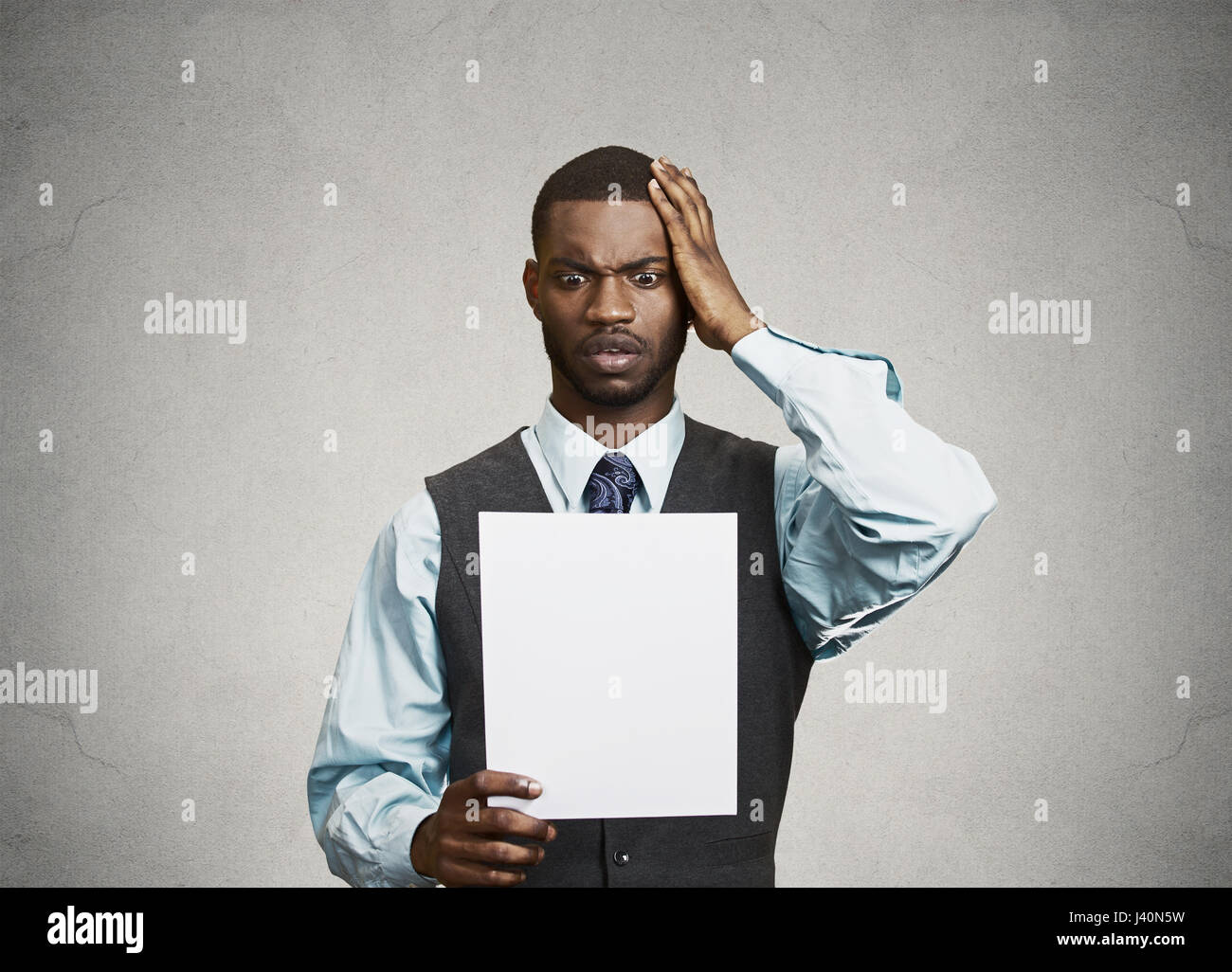 Closeup portrait shocked, funny looking young man, disgusted at monthly statement, test, application, results isolated grey background. Negative human Stock Photo