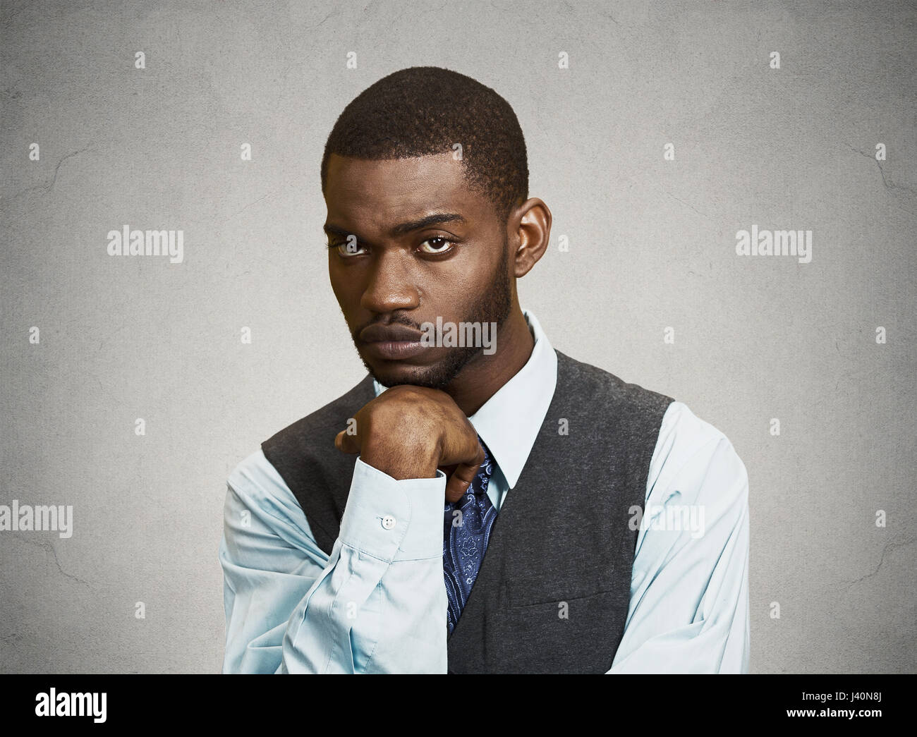 Closeup portrait man with sad expression, isolated on grey, black background. Human emotions, body language, life perception Stock Photo