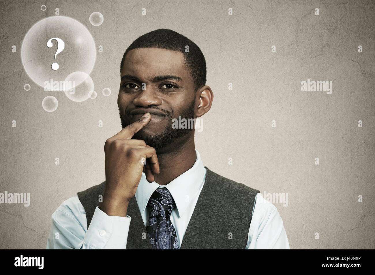 Closeup portrait young, puzzled business man thinking, deciding deeply about something finger on lips looking confused isolated black background with  Stock Photo