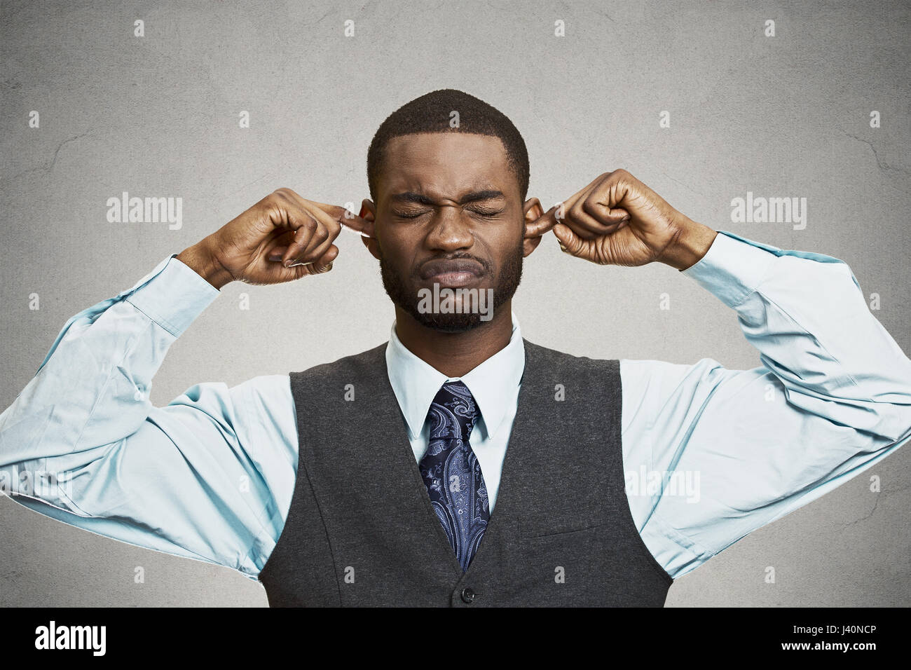 Closeup portrait unhappy, annoyed man plugging closing ears with fingers, disgusted ignoring something not wanting to hear someone side story, isolate Stock Photo