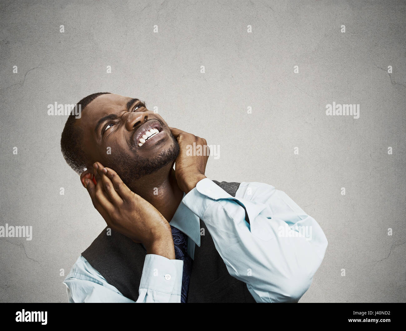 Closeup portrait young angry mad unhappy stressed man covering his ears