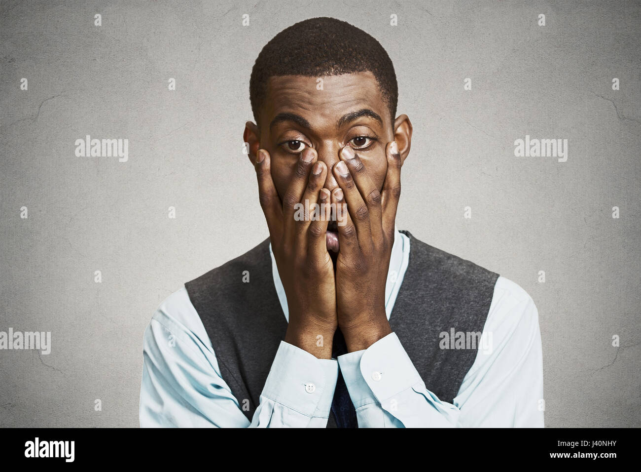 Closeup portrait, headshot young tired, fatigued business man worried, stressed, dragging face down with hands, isolated black, grey background. Negat Stock Photo