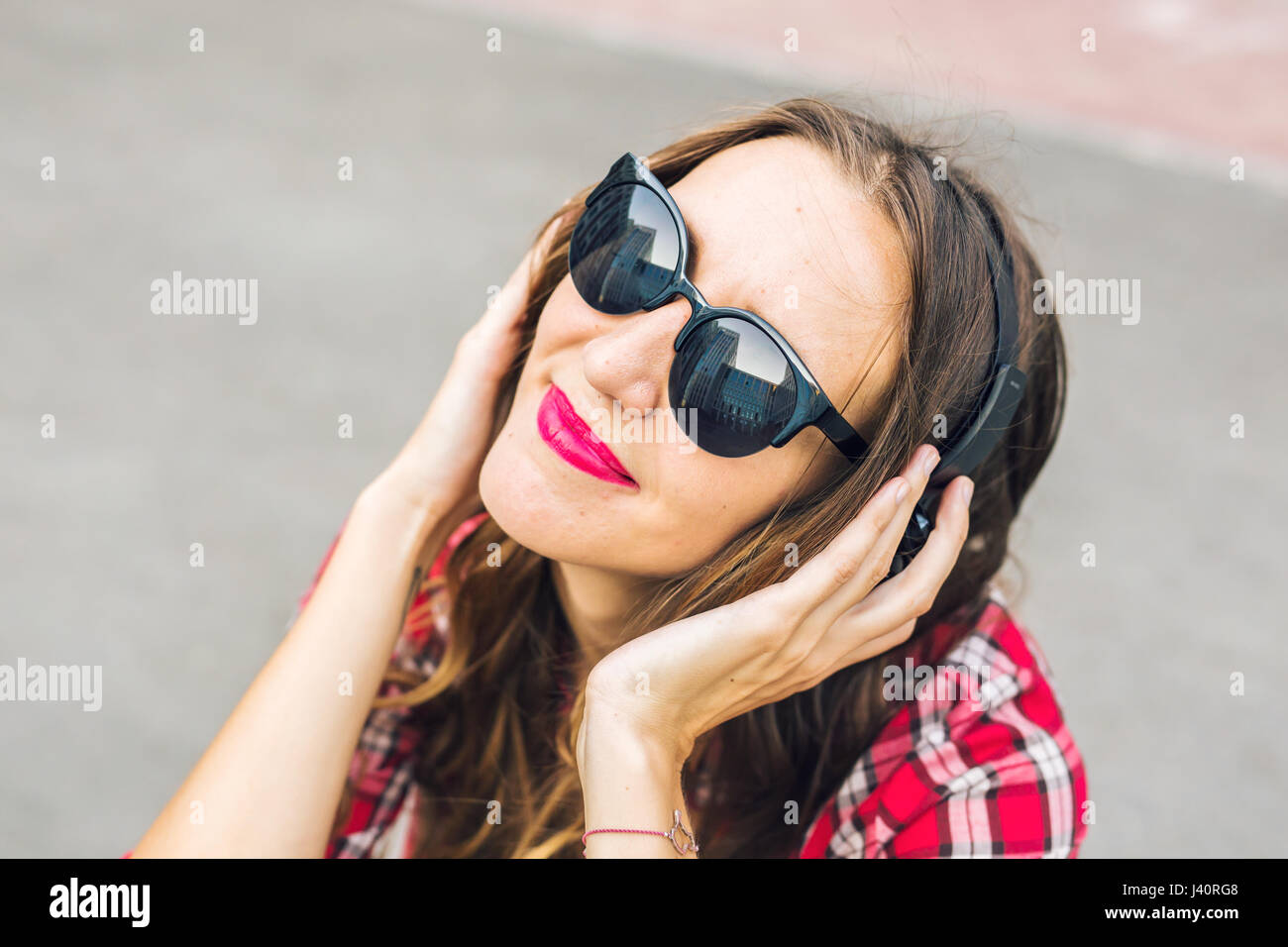 Young smiling woman relaxing and listening to music with headphones in ...