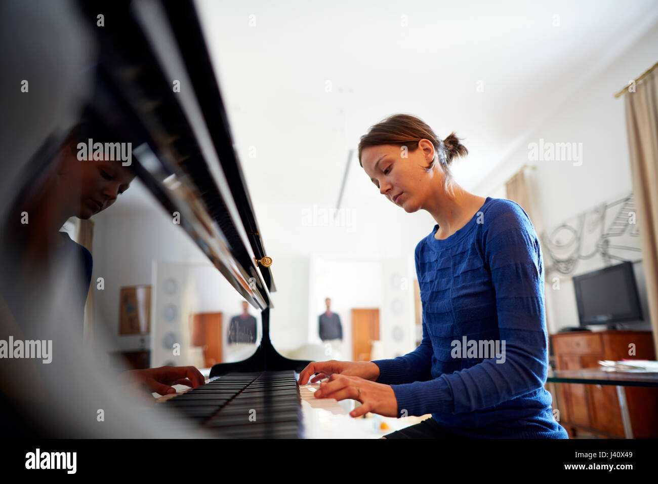 Young woman playing the piano in suite Boesendorf no.27, Altstadt Vienna Hotel, Kirchengasse 41, 7th district, Vienna, Austria Stock Photo