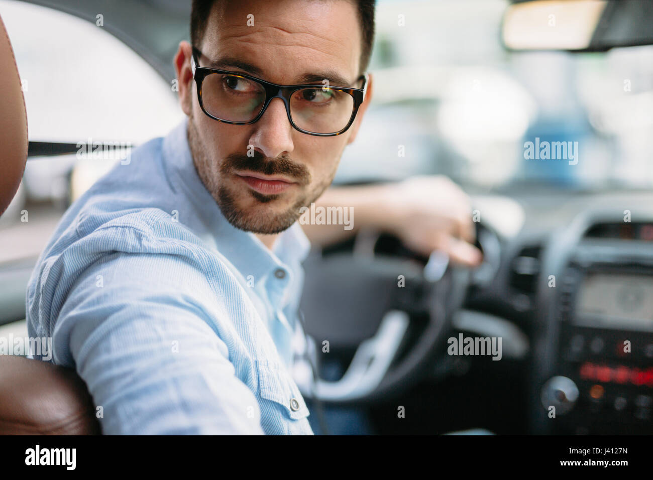 Portrait of a handsome businessman driving car Stock Photo - Alamy
