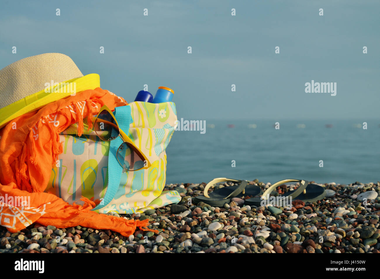 Straw hat, bag, sun glasses and flip flops on a sunny beach Stock Photo ...