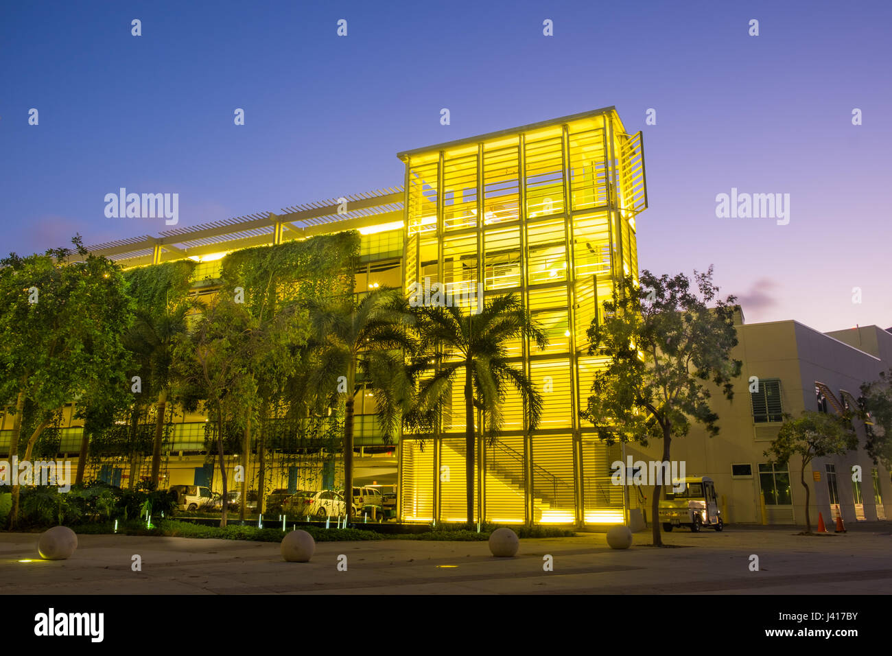 Colorful modern multi level parking in Camana Bay lit at dusk, Grand Cayman, Cayman Islands Stock Photo