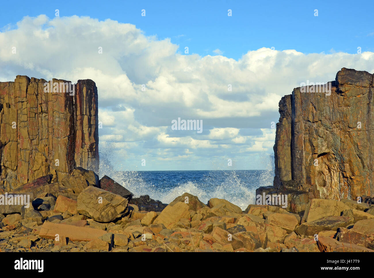 Waves breaking in the gap between basalt rock formations with a view to the sea at Bombo Headland quarry, New South Wales coast, Australia Stock Photo