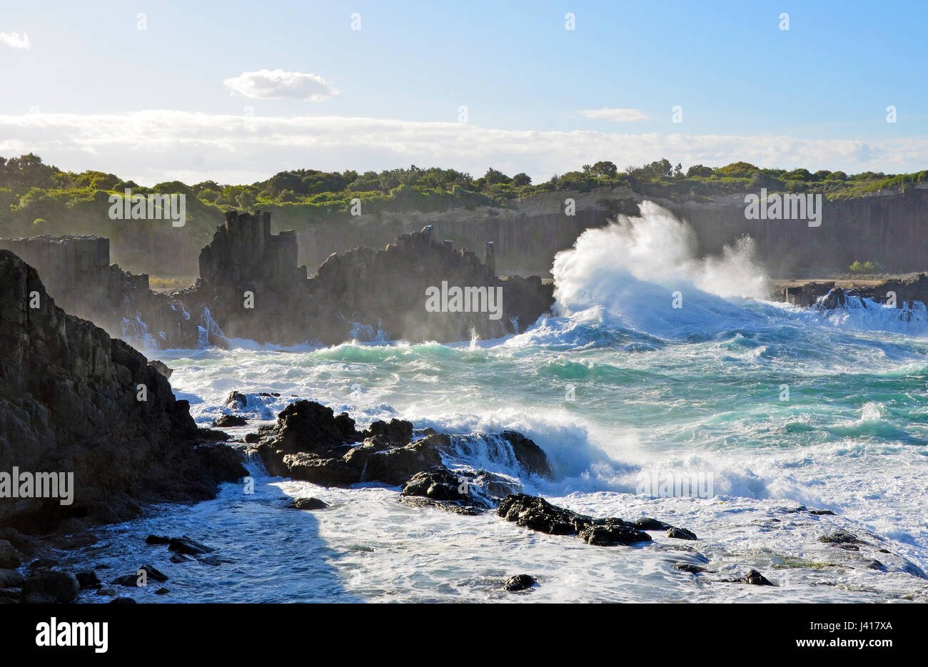 Rough seas and big swell breaking over basalt column rock formations at Bombo Headland quarry, New South Wales coast, Australia Stock Photo