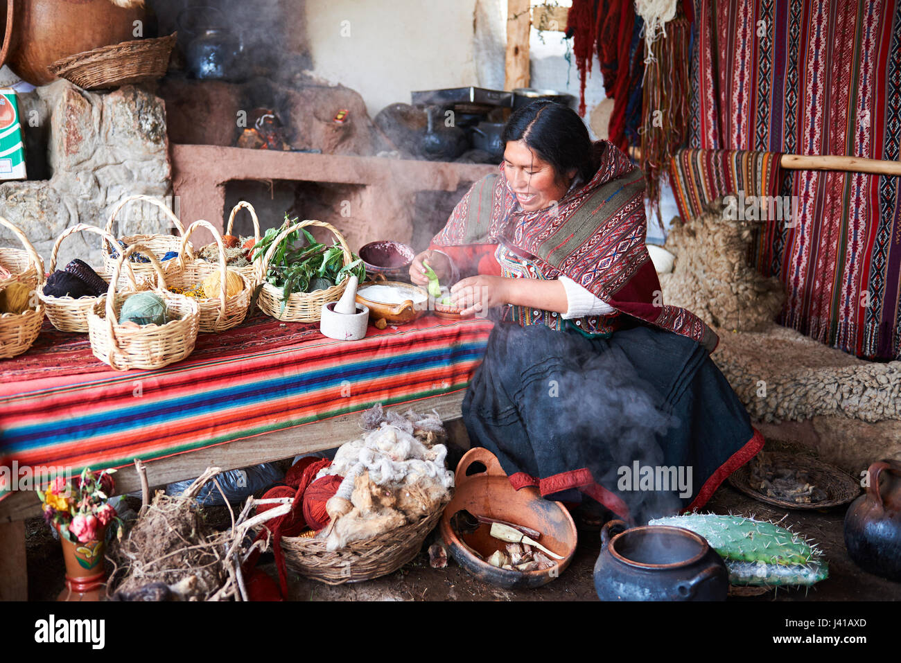 Cusco, Peru - April 21, 2017: Natural handmade wool clothes factory. Woman working with natural textile paint Stock Photo