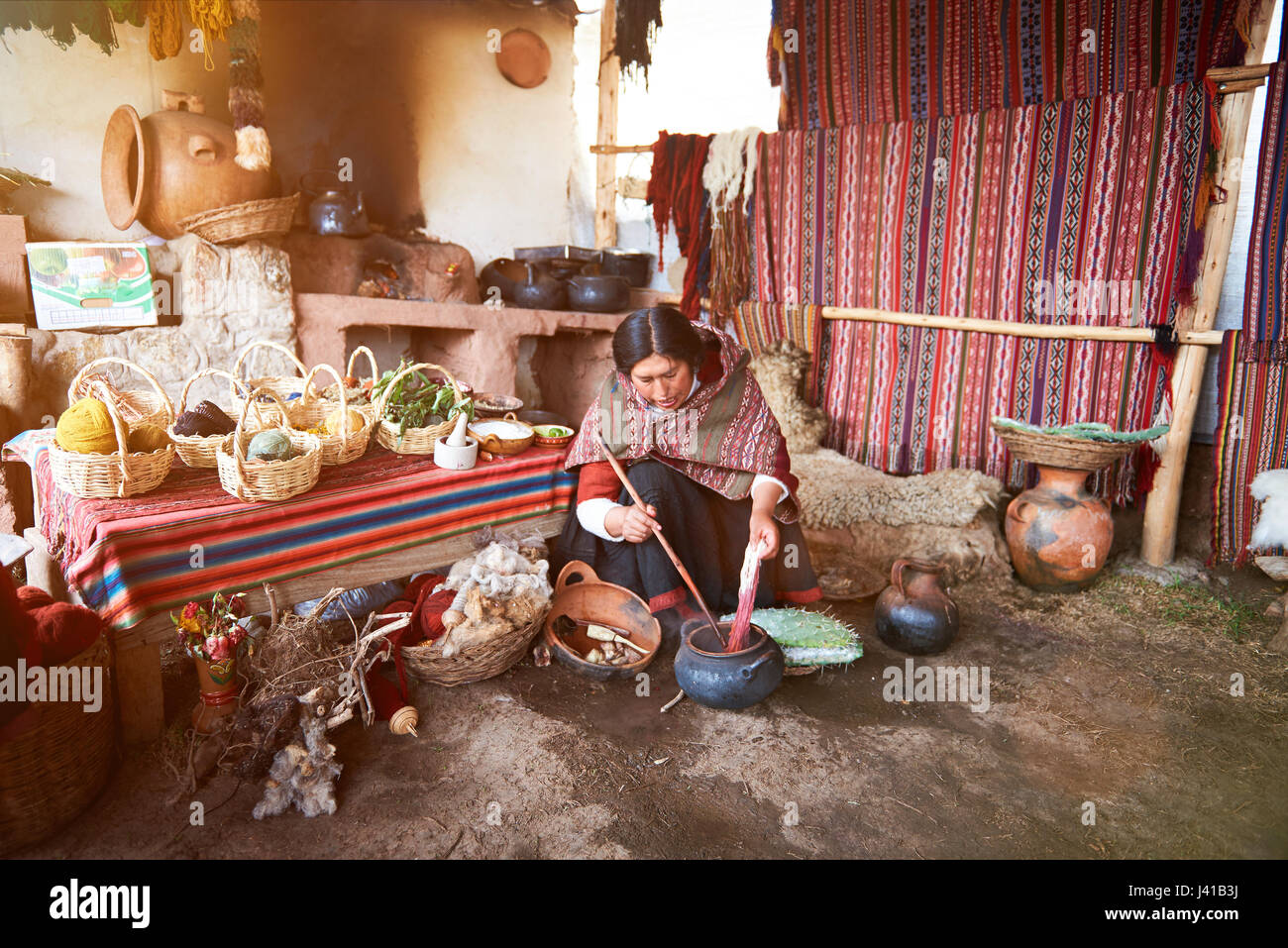 Cusco , Peru - April 21, 2017: Woman work in alpaca traditional handmade manufacture. Peruvian woman paint wool Stock Photo