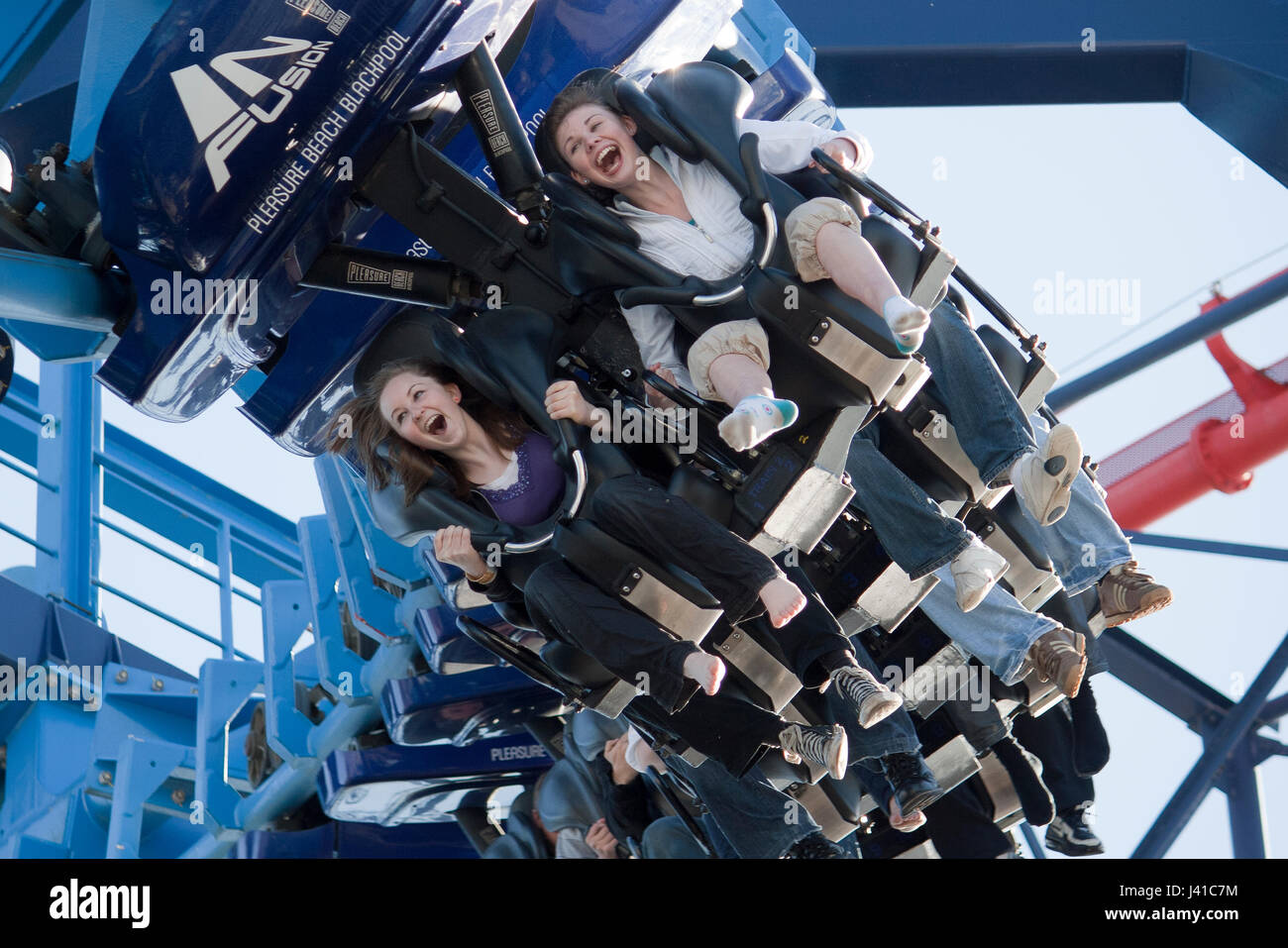 young adult females laughing and screaming on fairground ride Stock Photo