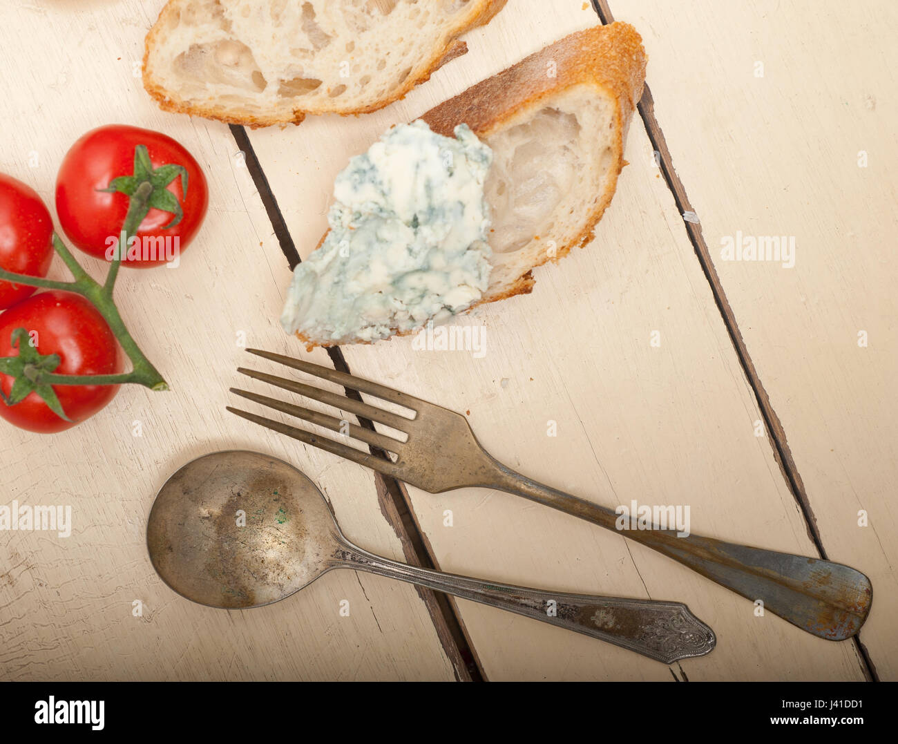 fresh blue cheese spread ove french baguette with cherry tomatoes on side Stock Photo