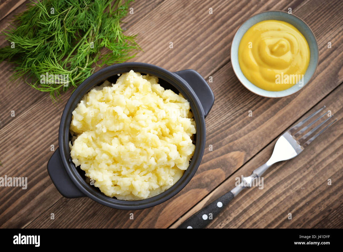 Mashed potatoes in bowl on wooden background closeup, top view Stock Photo