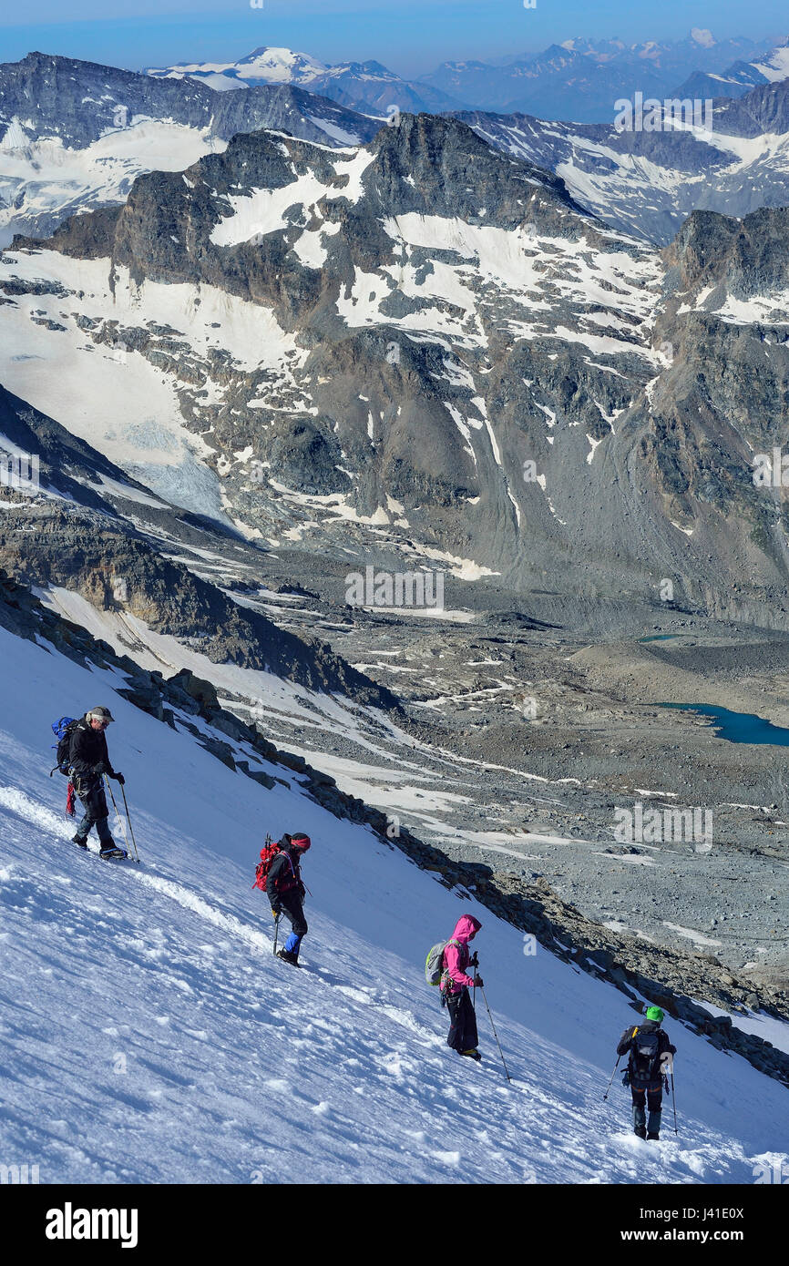Several persons descending on glacier from Gran Paradiso, Gran Paradiso, Gran Paradiso Nationalpark, Graian Alps range, valley of Aosta, Aosta, Italy Stock Photo