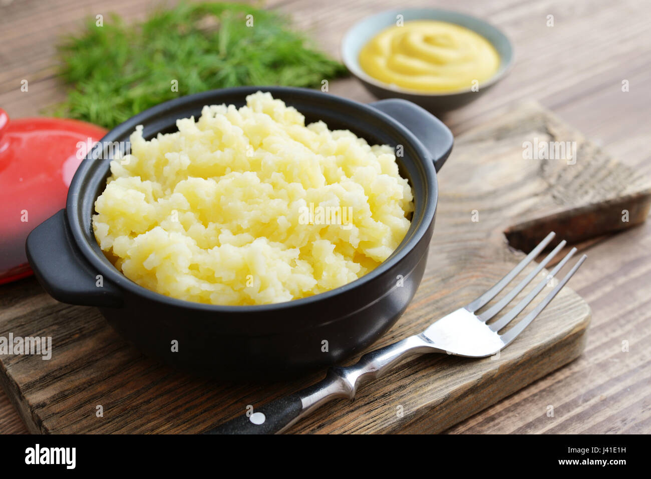 Mashed potatoes in bowl on wooden background closeup Stock Photo