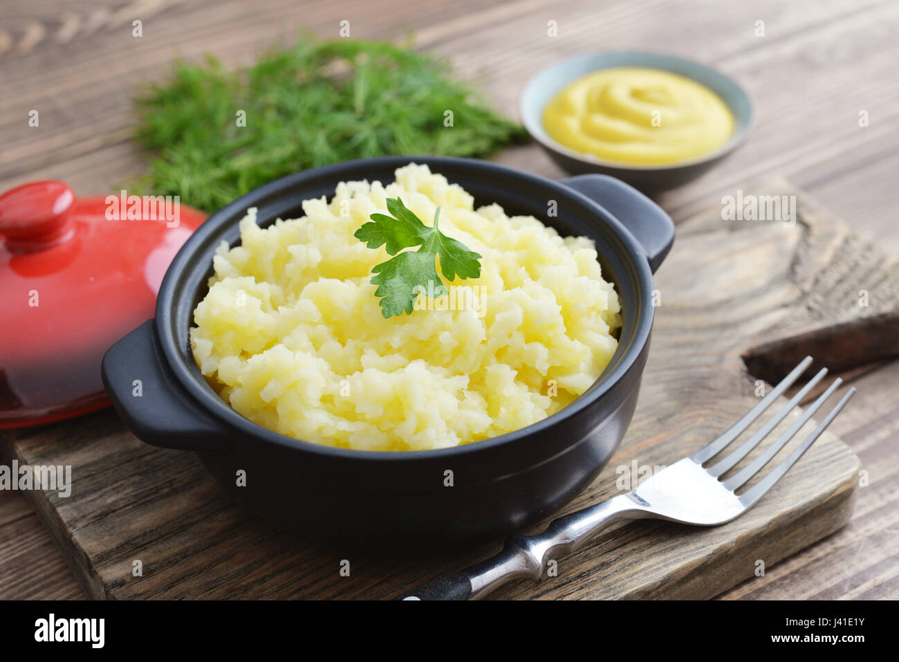 Mashed potatoes in bowl on wooden background closeup Stock Photo
