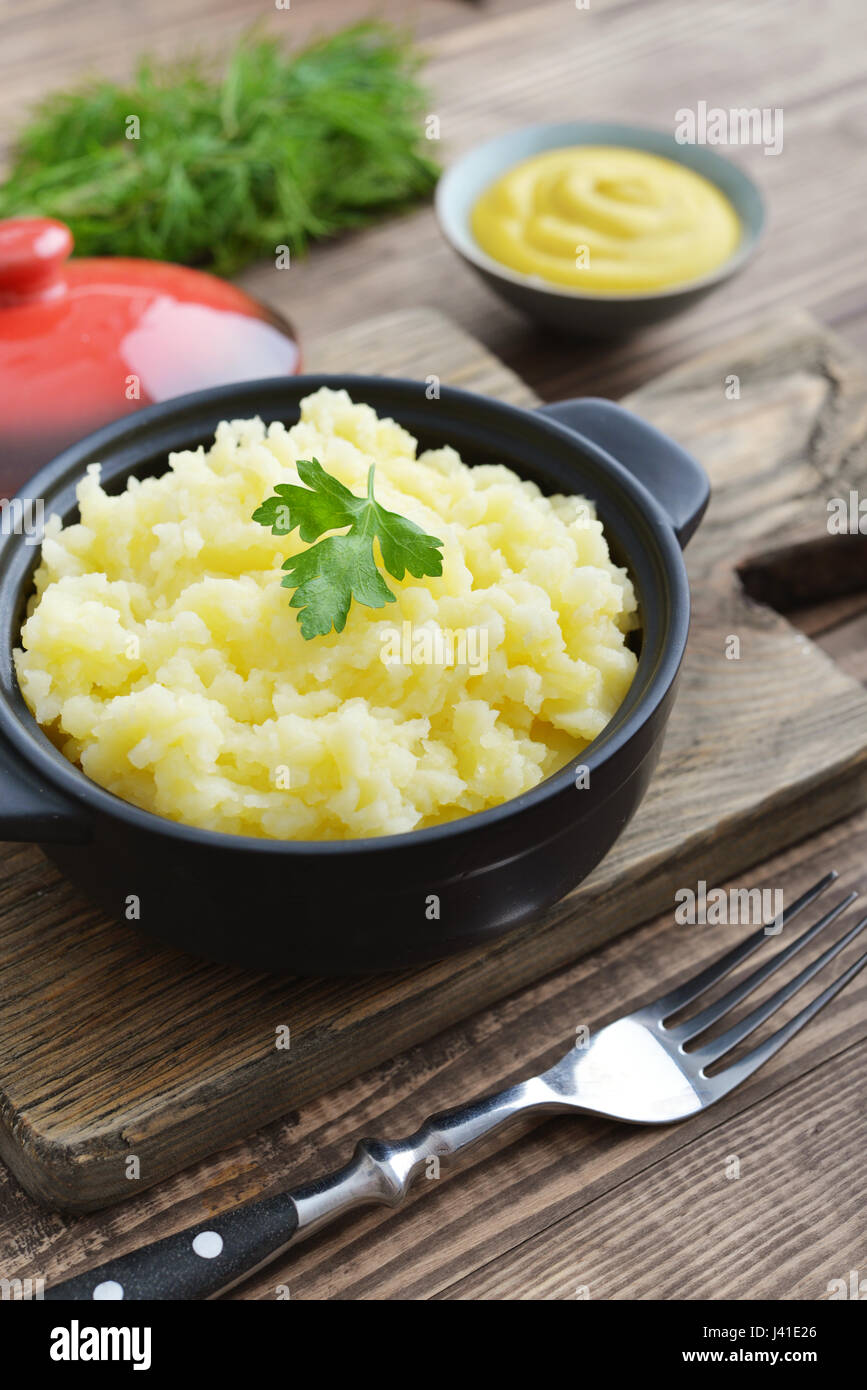 Mashed potatoes in bowl on wooden background closeup Stock Photo