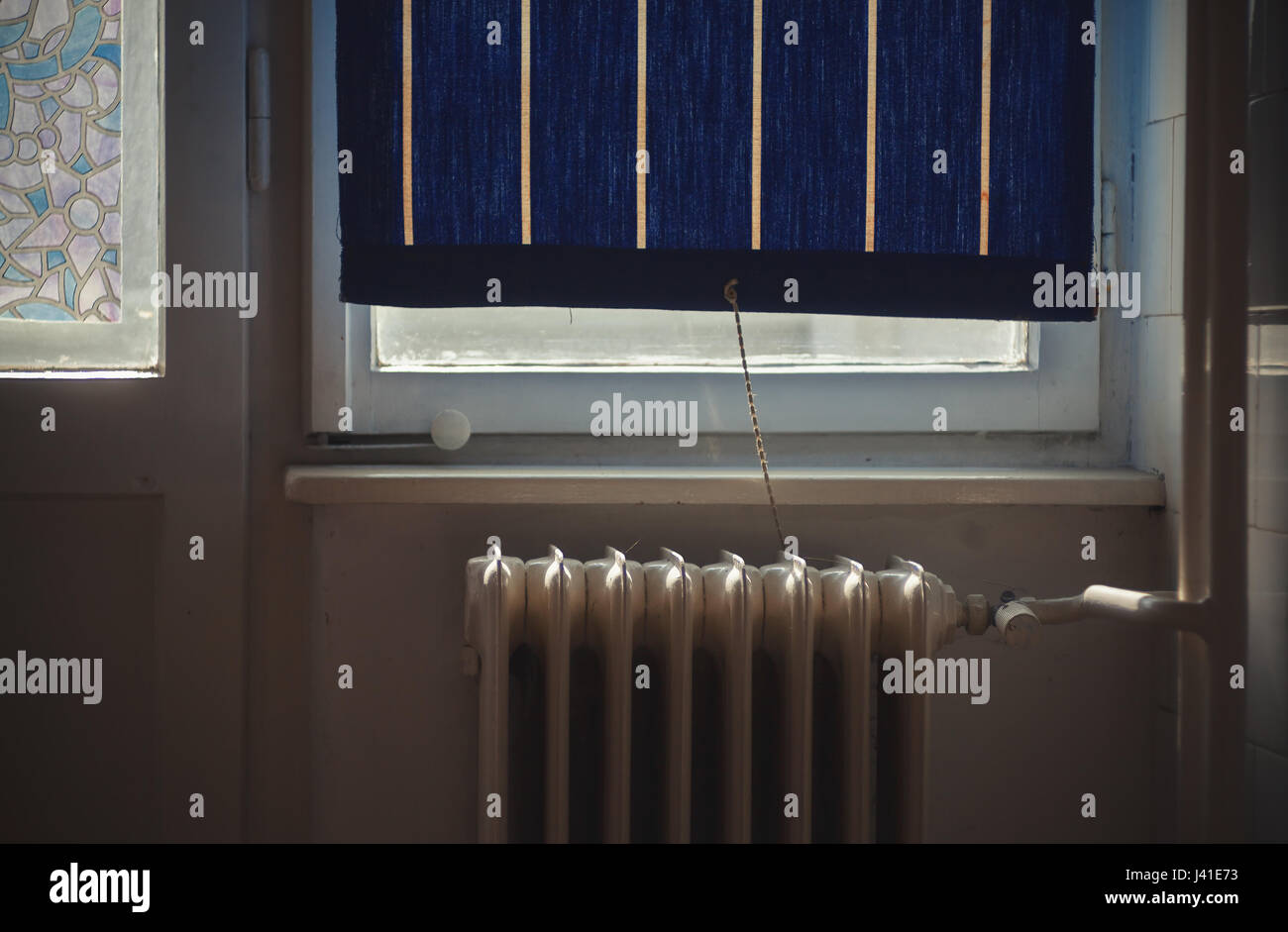 Part of an old retro style interior, details of an old radiator in front of window during day. Stock Photo