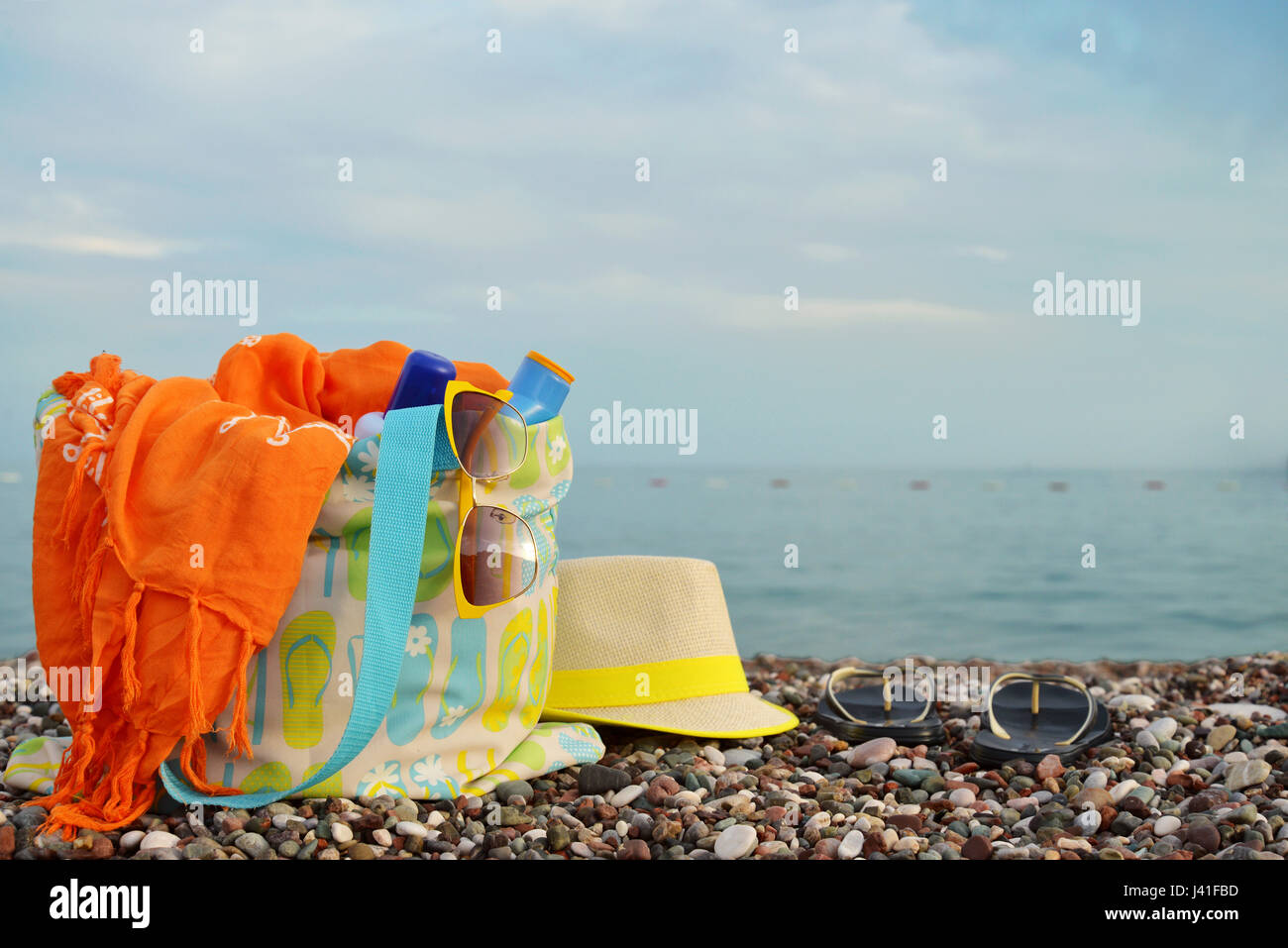 Straw hat, bag, sunglasses and flip flops on a sunny beach Stock Photo ...